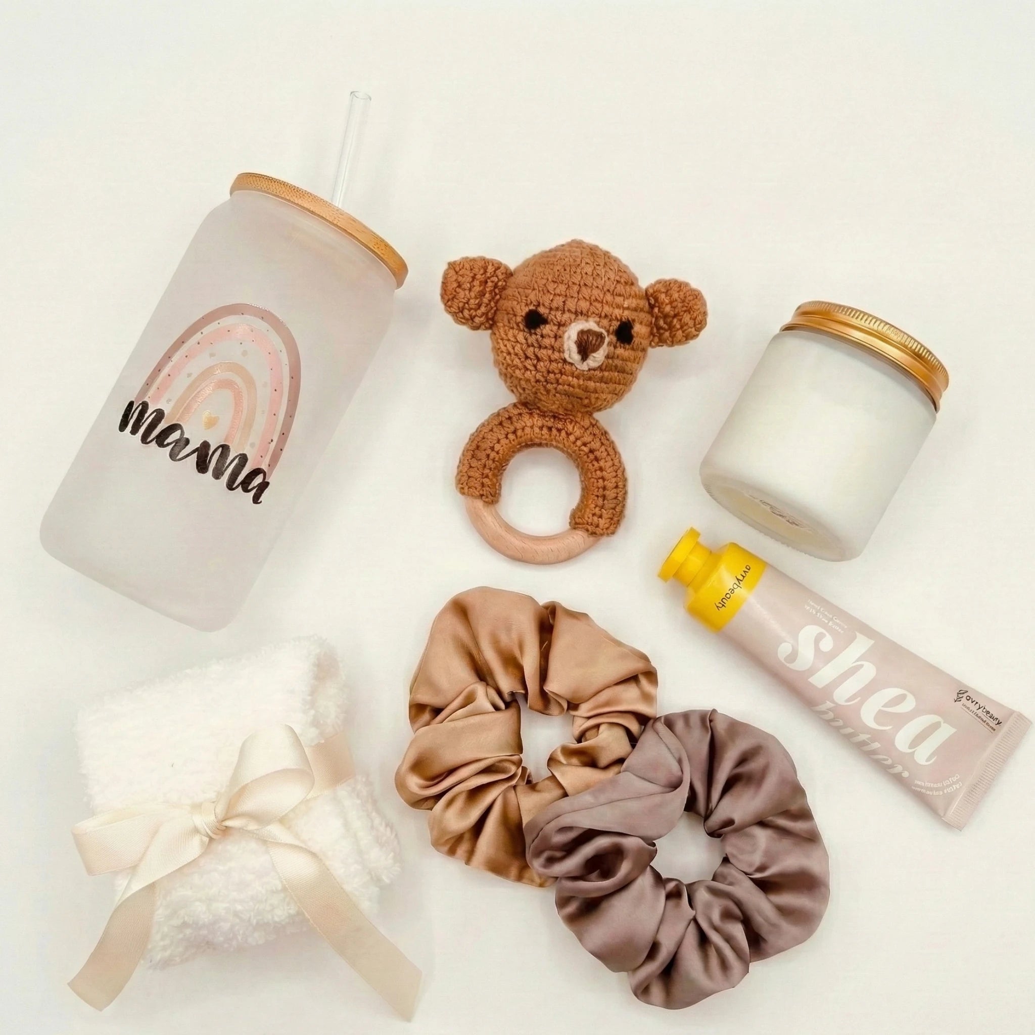 Top down flat lay view of Baby Rattle box items including shea hand cream and scented candle