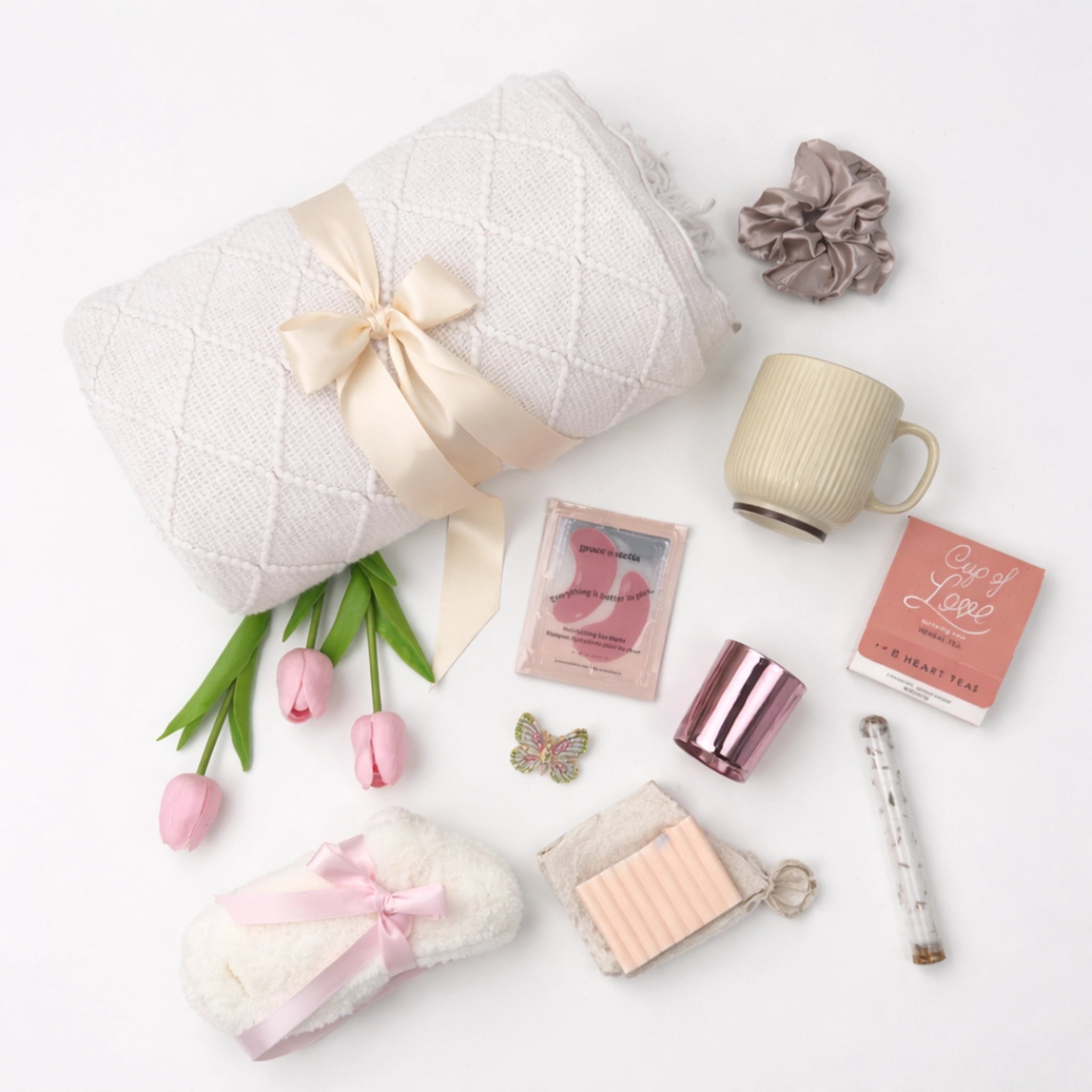 Flat lay self care gift box with throw blanket, mug, herbal tea, fluffy socks and spa items