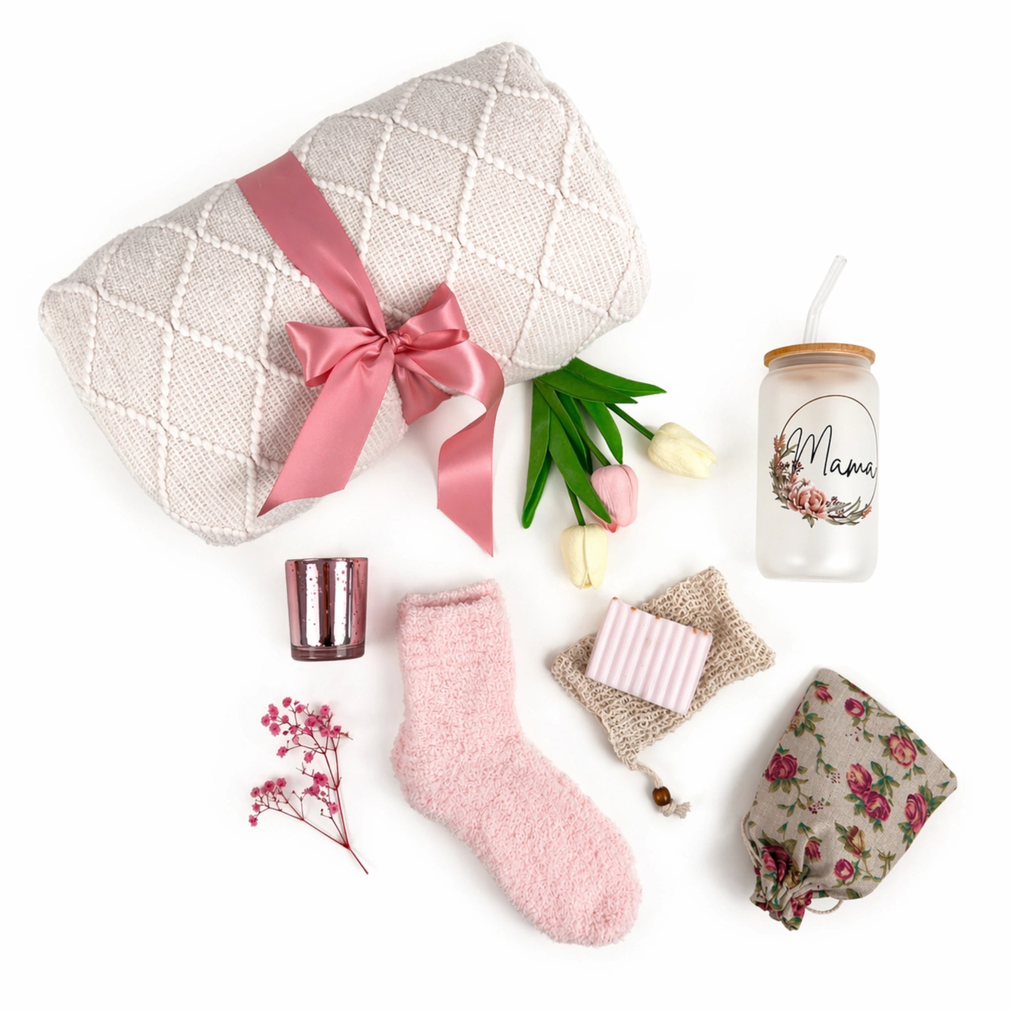 Flat lay Mama gift box with blanket, tumbler, candle holder, soap, cozy socks and floral pouch arranged on white background