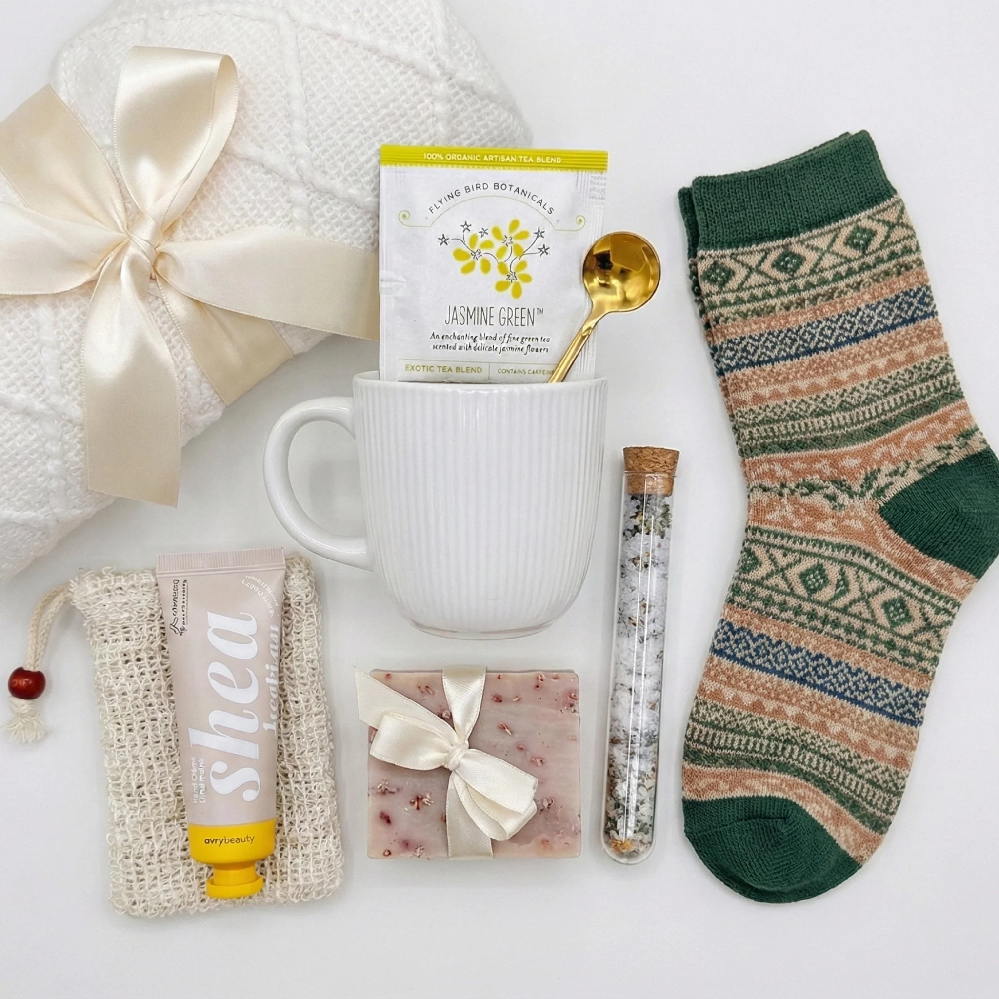 Top down flat lay view of relaxation gift box items including bath salts vial and nordic socks