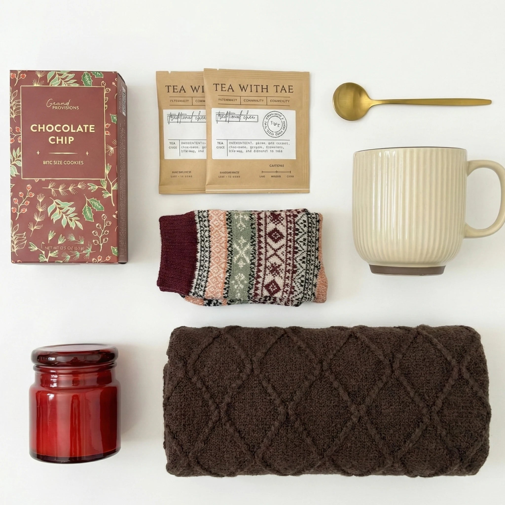 Top down flat lay view of Santa Baby box items including chocolate chip cookies and gold spoon