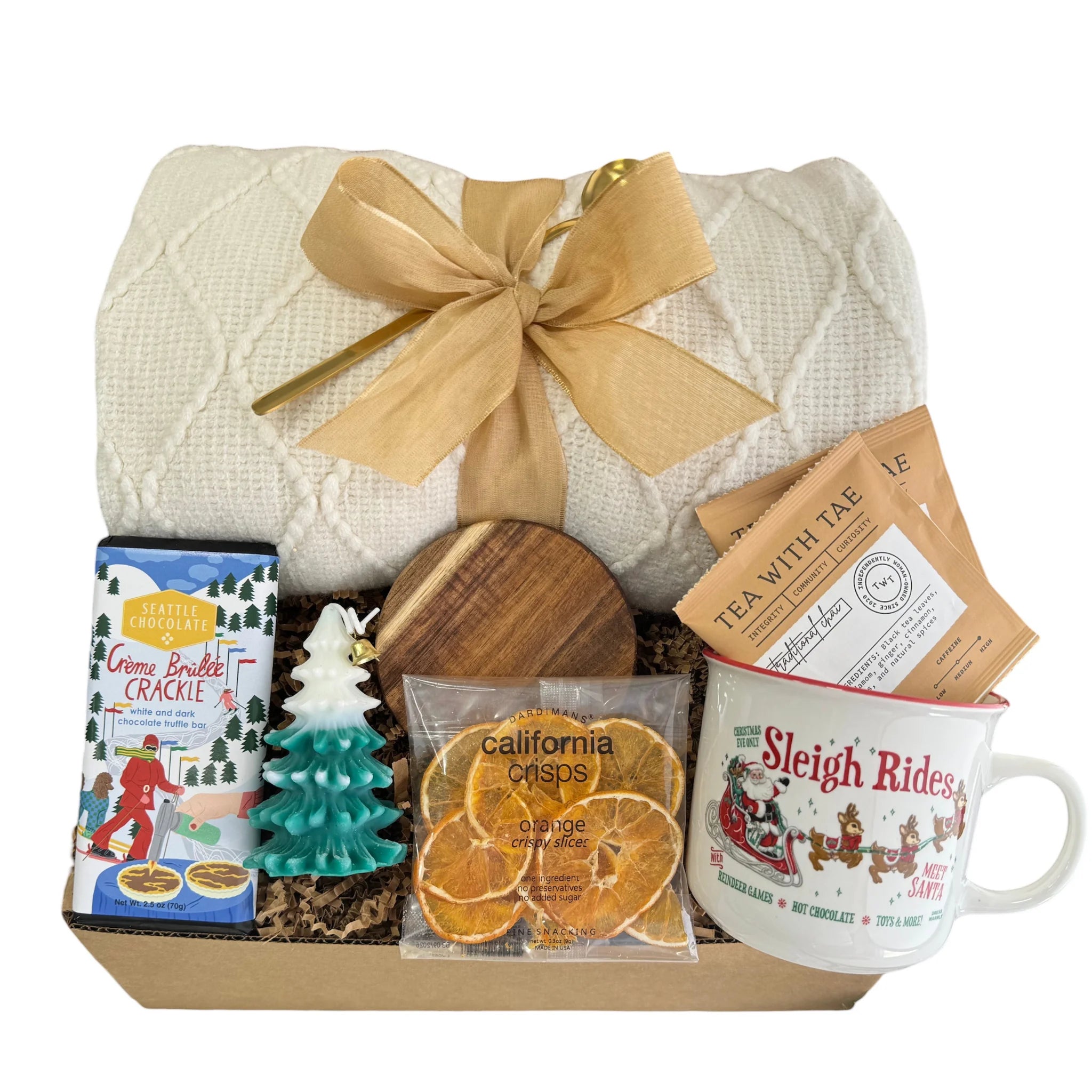 Sleigh Rides Gift Box featuring a throw blanket, gourmet chocolate, dried orange slices, Christmas coffee mug, golden coffee spoon, herbal tea, Christmas tree candle, and wooden coaster.