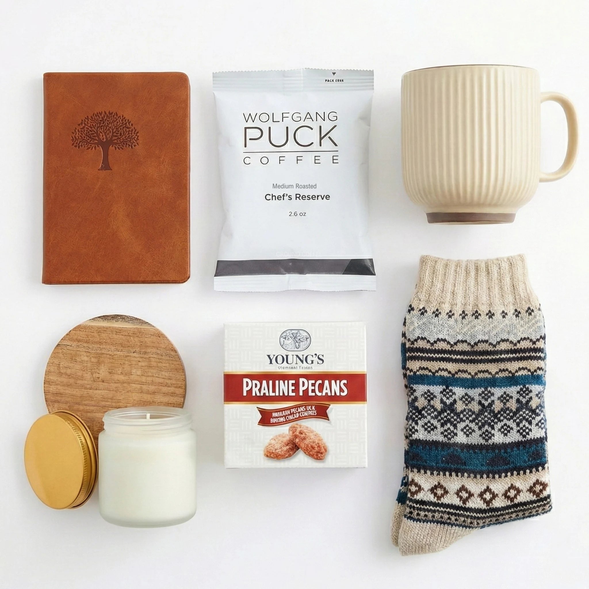 Top down flat lay view of coffee gift box items including ceramic mug, nordic socks and pecans