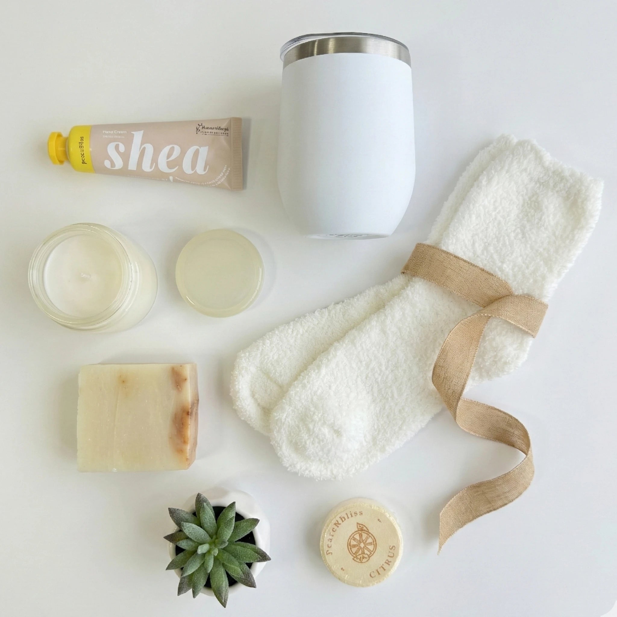 Top down flat lay view of Take It Easy box items including shea cream, candle and fluffy socks