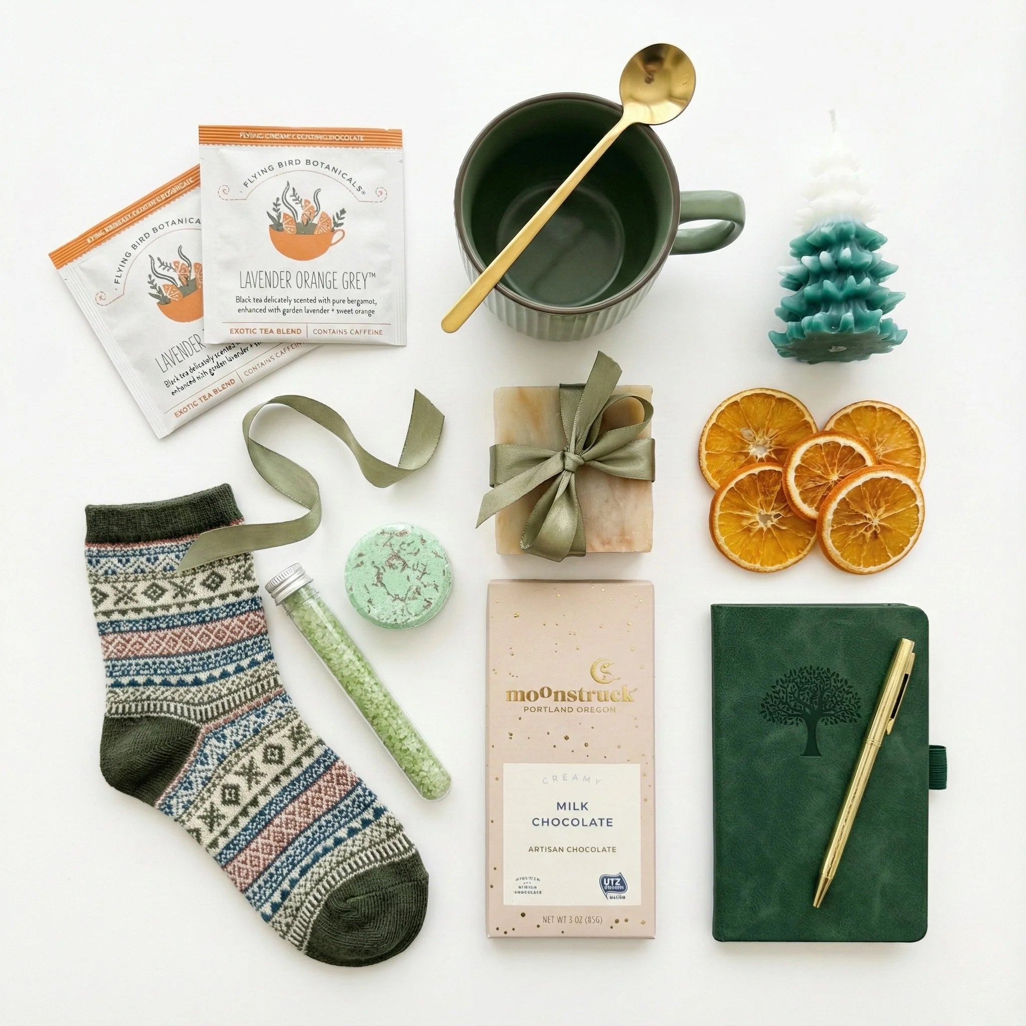 Winter wonderland Christmas gift box with items including socks, a mug, and a notebook on a white background
