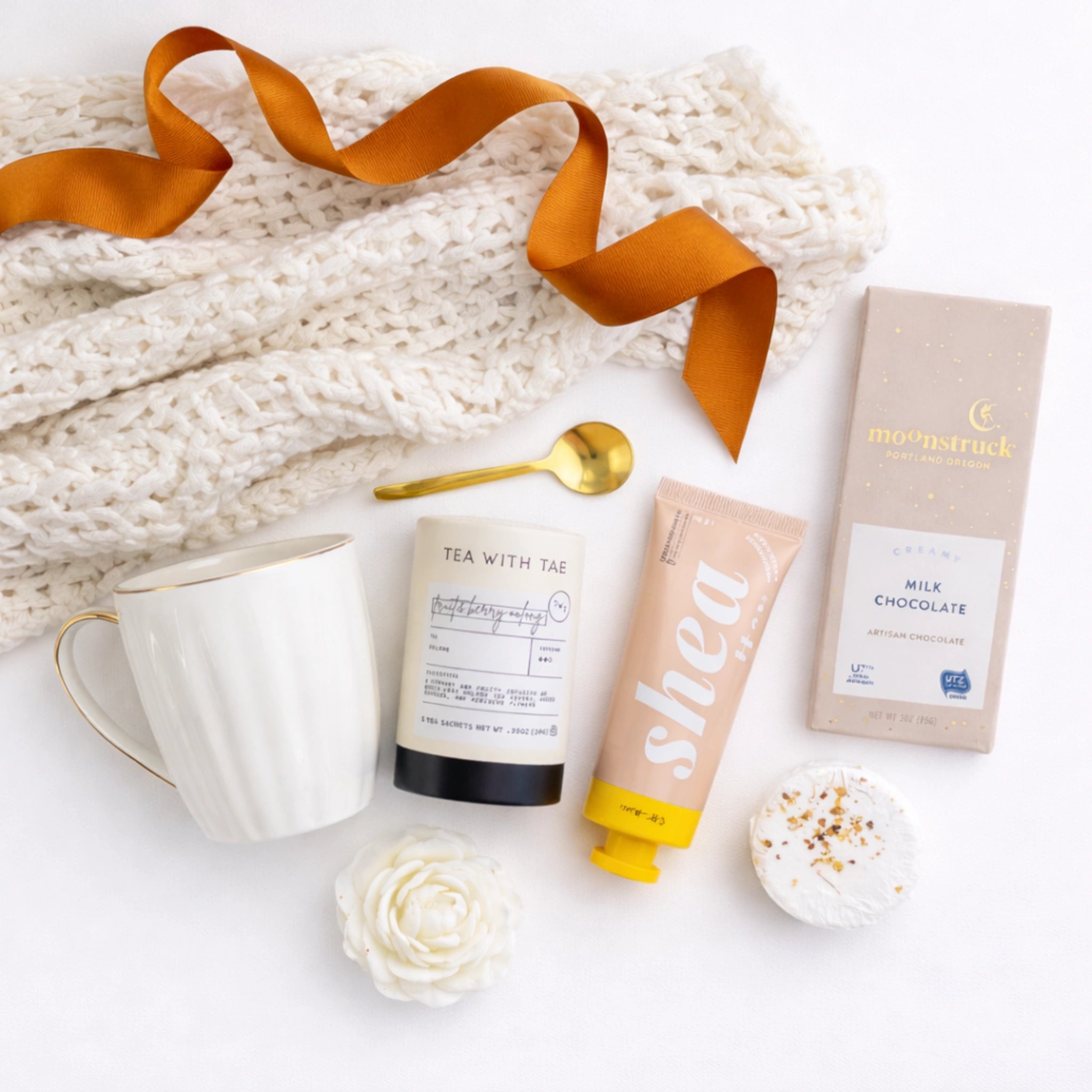 Top down flat lay view of You Matter box items including gourmet chocolate and golden spoon