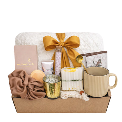 Send a Hug in a Box gift box for women featuring throw blanket, chocolate, candle, mug, herbal tea and spa self care items