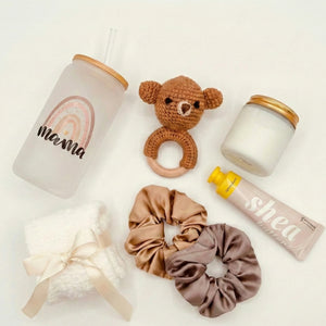 Top down flat lay view of Baby Rattle box items including shea hand cream and scented candle