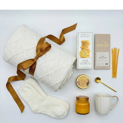 Top down flat lay view of Beauty Cozy Life box items including Bridgerton tea and lemon shortbread