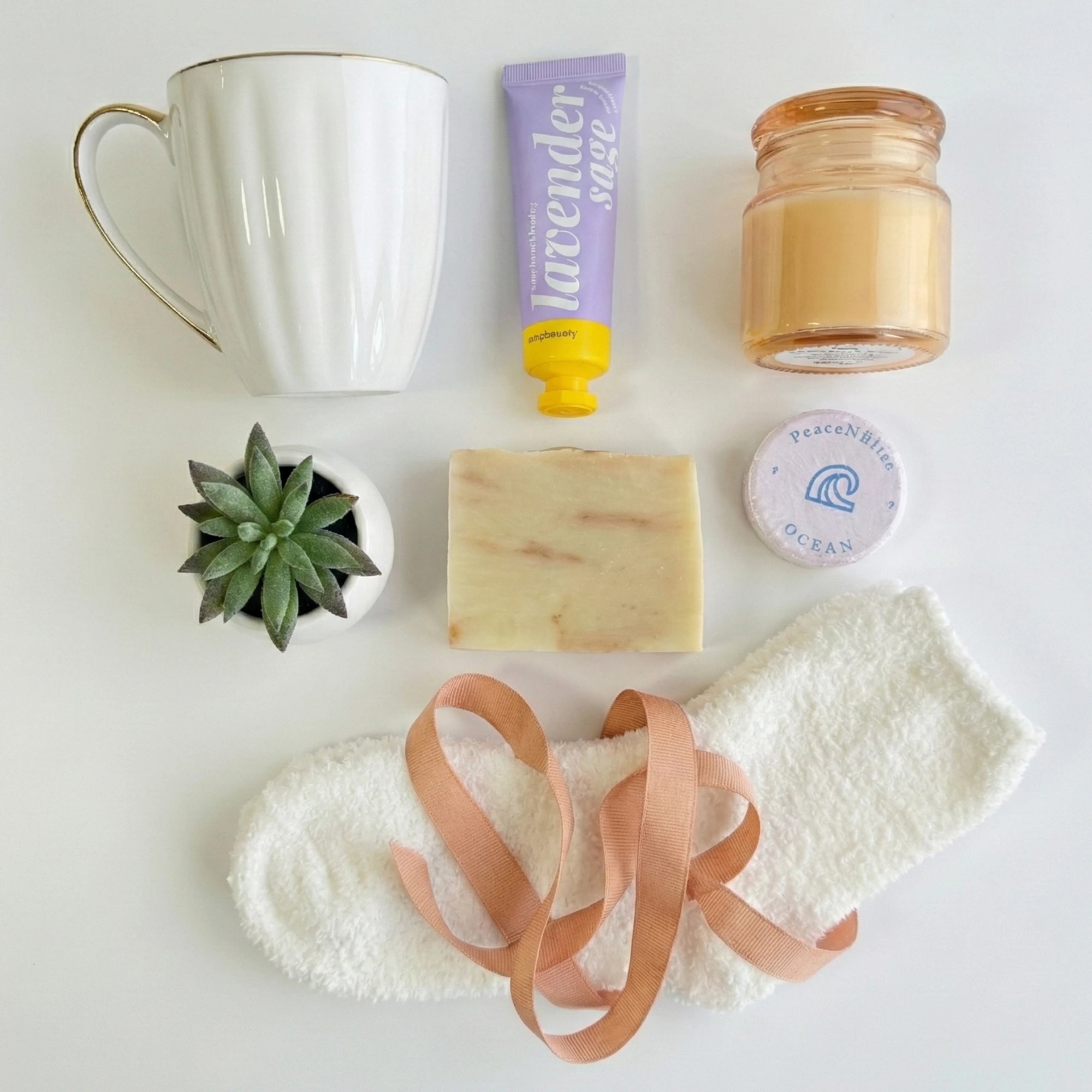 Top down flat lay view of Bliss Box items including candle, succulent and fluffy socks
