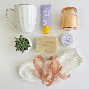 Top down flat lay view of Bliss Box items including candle, succulent and fluffy socks