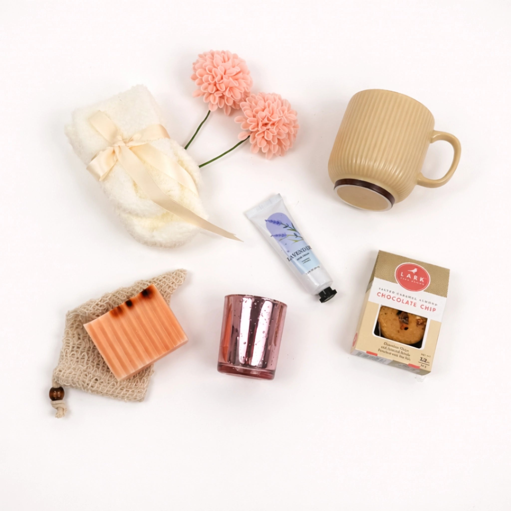 Flat lay self care gift box for women featuring, mug, handmade soap, lavender hand cream and candle holder