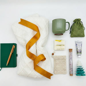 Top down flat lay view of Calm Holiday box items including notebook, soap, and hand cream