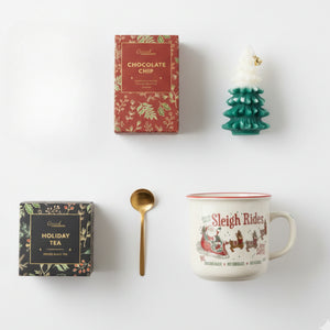 Top down flat lay view of Christmas Time box items including
chocolate chip cookies and tree candle