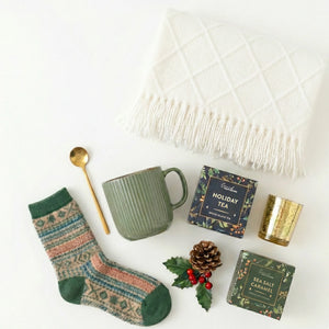 Top down flat lay view of Christmas Treat box items including caramel cookies and holiday tea