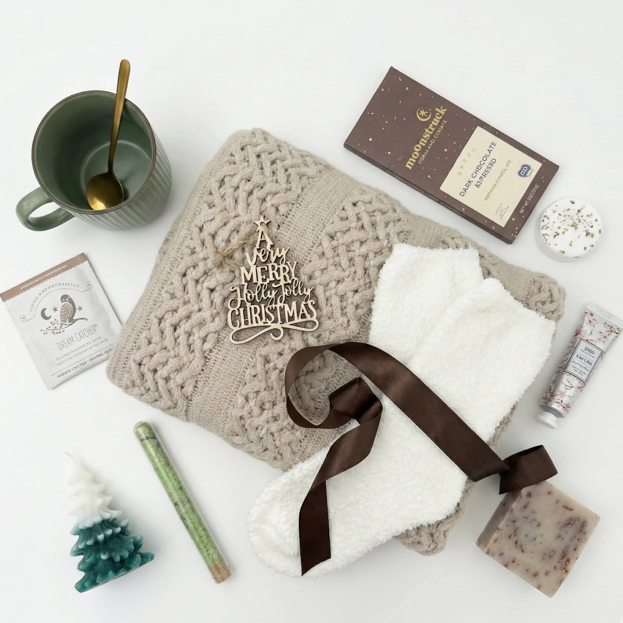 Top down flat lay view of Hallelujah box items including tree shaped candle and wooden ornament