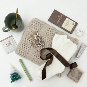 Top down flat lay view of Hallelujah box items including tree shaped candle and wooden ornament