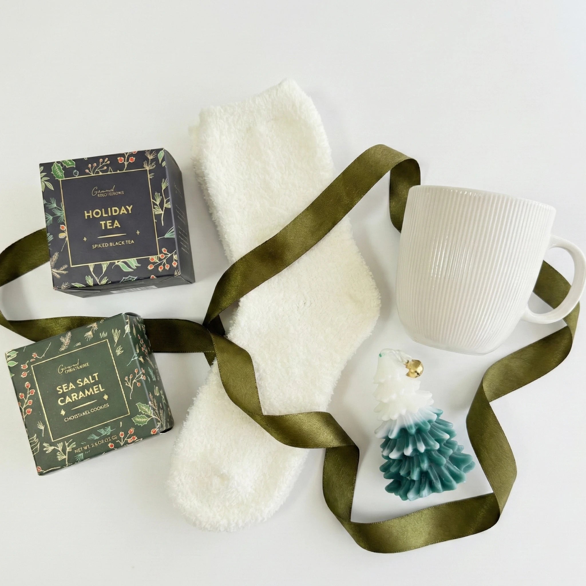 Top down flat lay view of Jingle Bells box items including Christmas tree candle and gourmet cookies