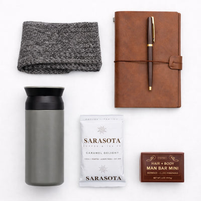Top down flat lay view of Modern Voyager items including olive tumbler and caramel coffee