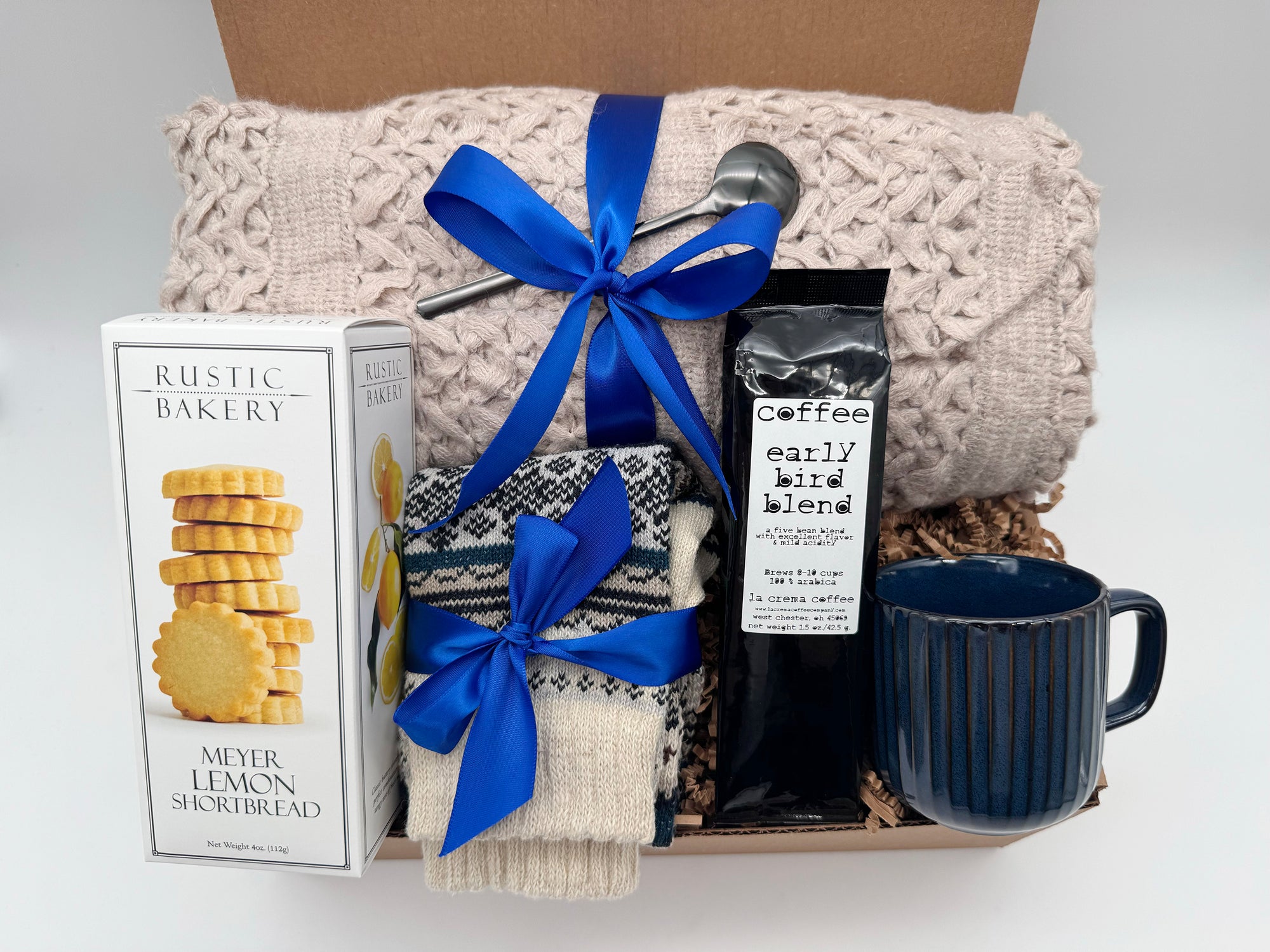 Nordic Coffee Comfort Box with blanket, Nordic socks, Early Bird coffee, shortbread cookies, mug, and golden spoon in a cozy winter gift arrangement