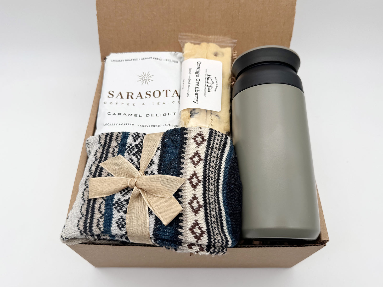 Nordic Warmth Gift Box featuring a travel tumbler, artisan coffee, cookies, and Nordic socks arranged in a cozy Arinna Gifts package.