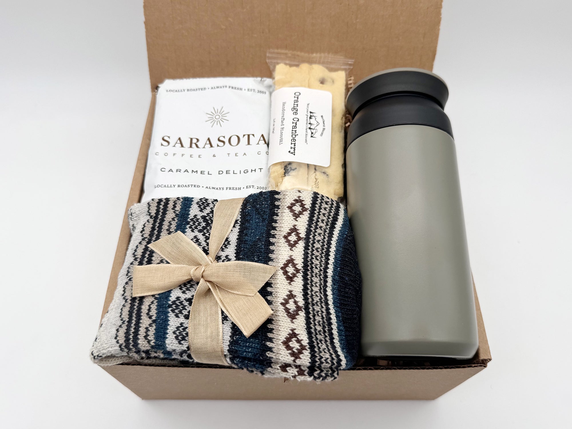 Nordic Warmth Gift Box featuring a travel tumbler, artisan coffee, cookies, and Nordic socks arranged in a cozy Arinna Gifts package.