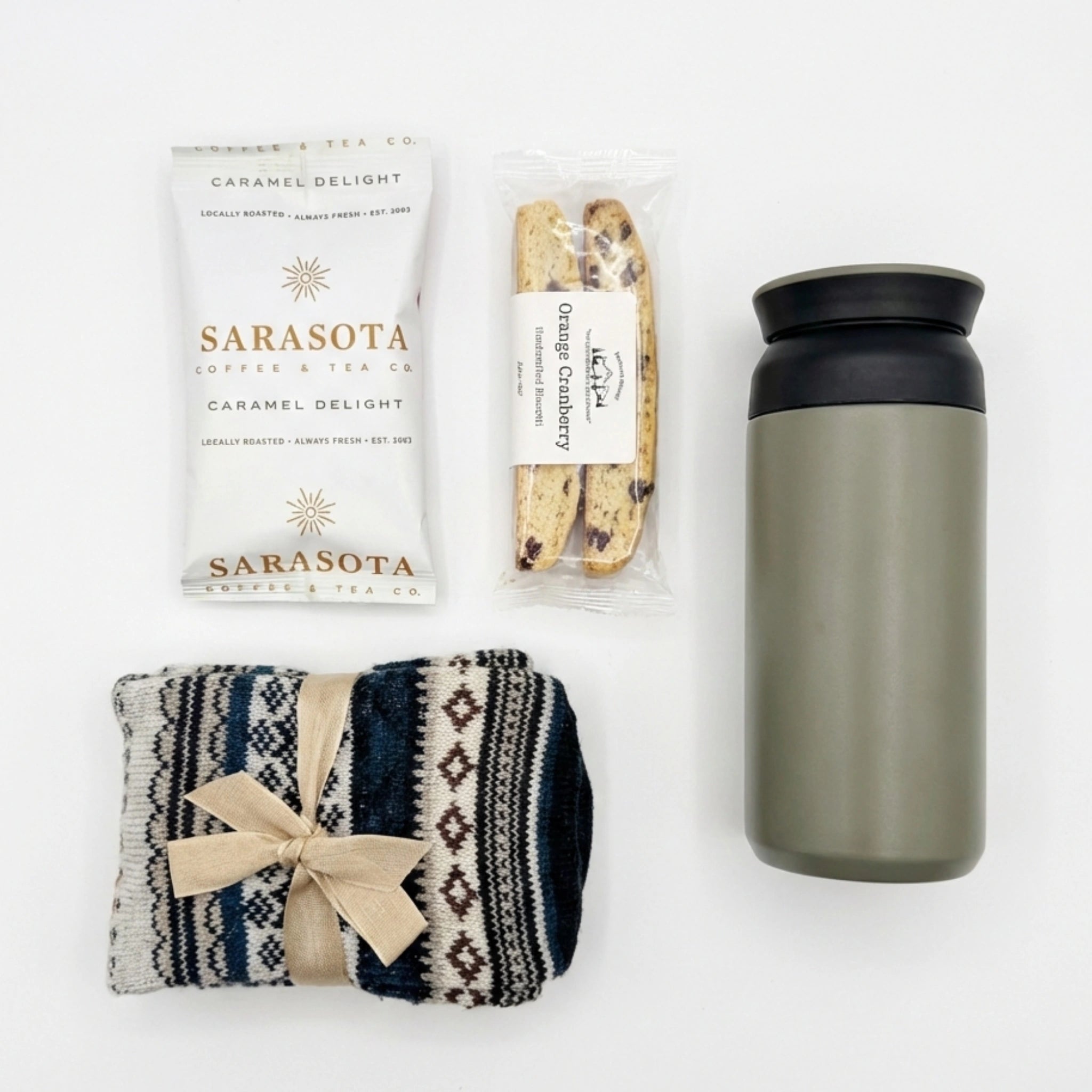Top down flat lay view of winter gift set items including nordic socks and coffee