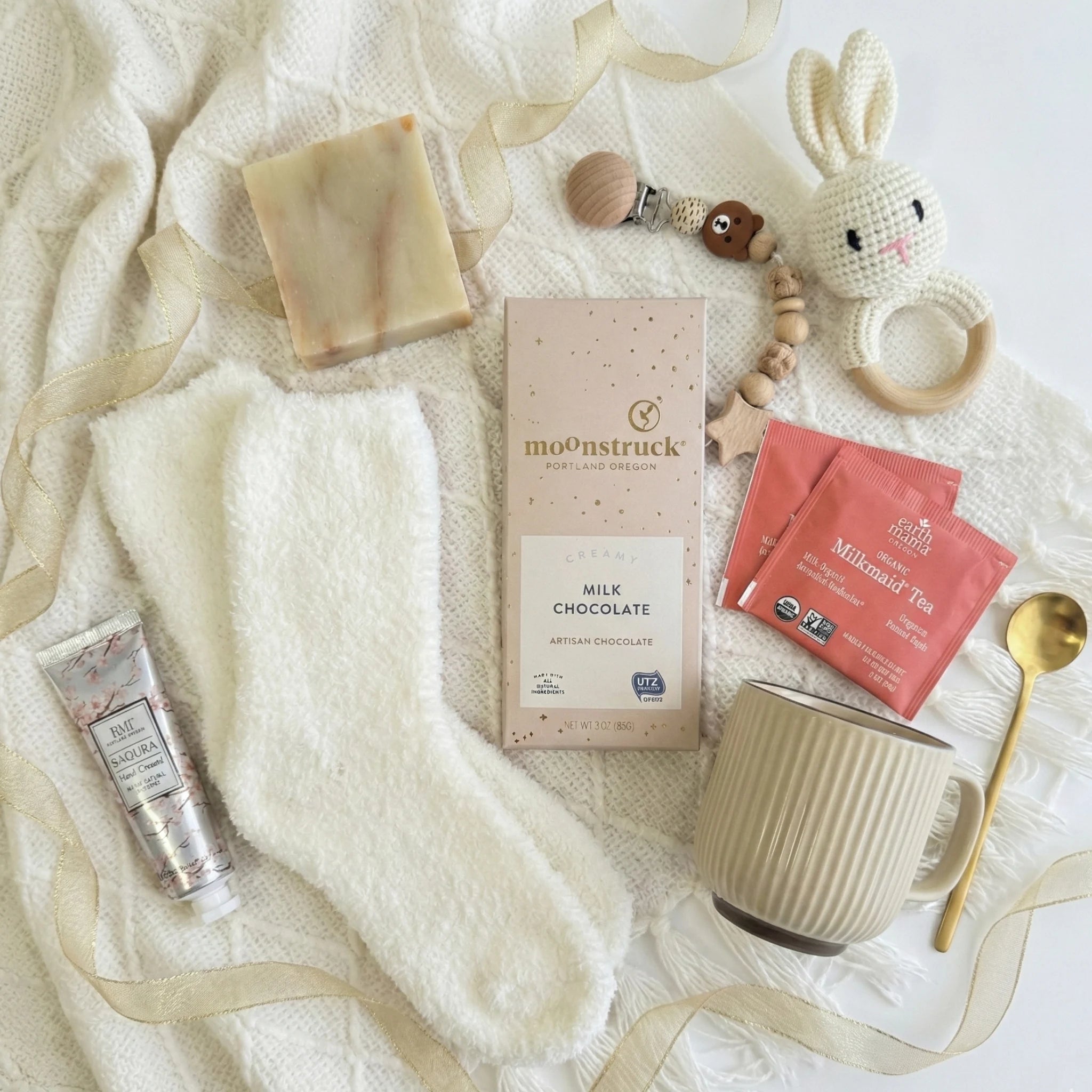 Top down flat lay view of O Baby box items including pacifier chain and organic tea