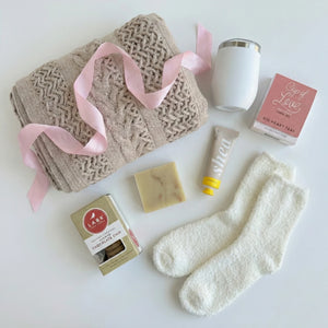 Top down flat lay view of Out of Office box items including Cup of Love tea and fluffy socks