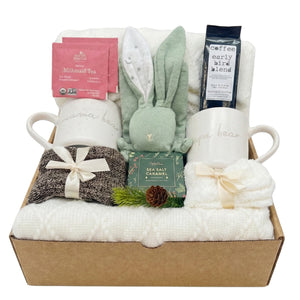 Parents Relax Box gift set with Mama and Papa Bear mugs, cozy throw blanket, baby security blanket, coffee, herbal tea, caramel treat, and socks arranged in a kraft gift box.