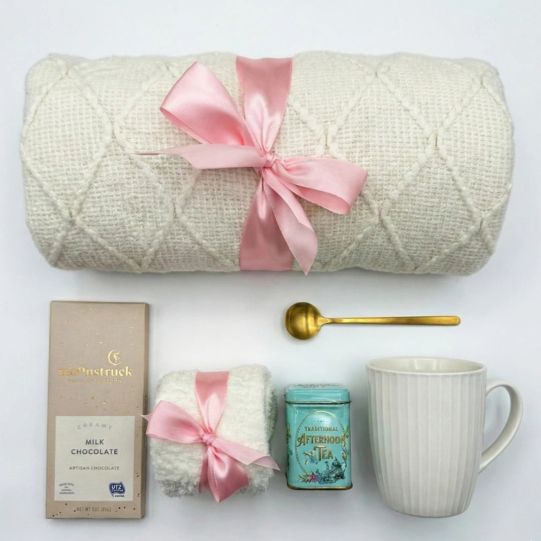 Sending Love and Hug gift basket with white knit blanket, pink ribbon and tea by Arinna Gifts in Dallas