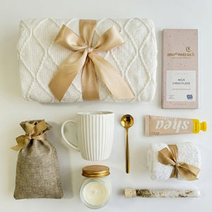 Top down flat lay view of relaxation gift set items including fluffy socks and hand cream