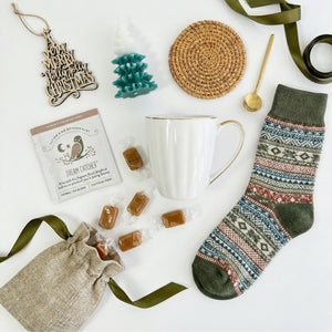 Top down flat lay view of Silent Night box items including wooden ornament and tree candle