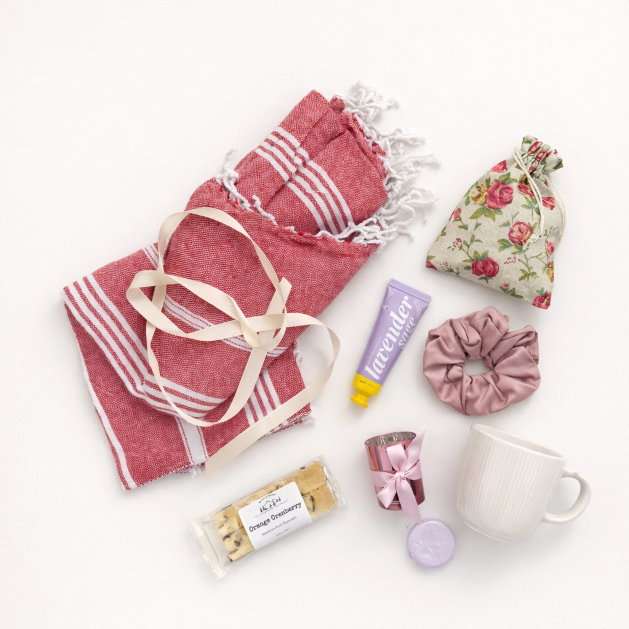 Flat lay gift box for women featuring Turkish cotton towel, biscotti cookies, mug, candle holder, herbal tea and spa items