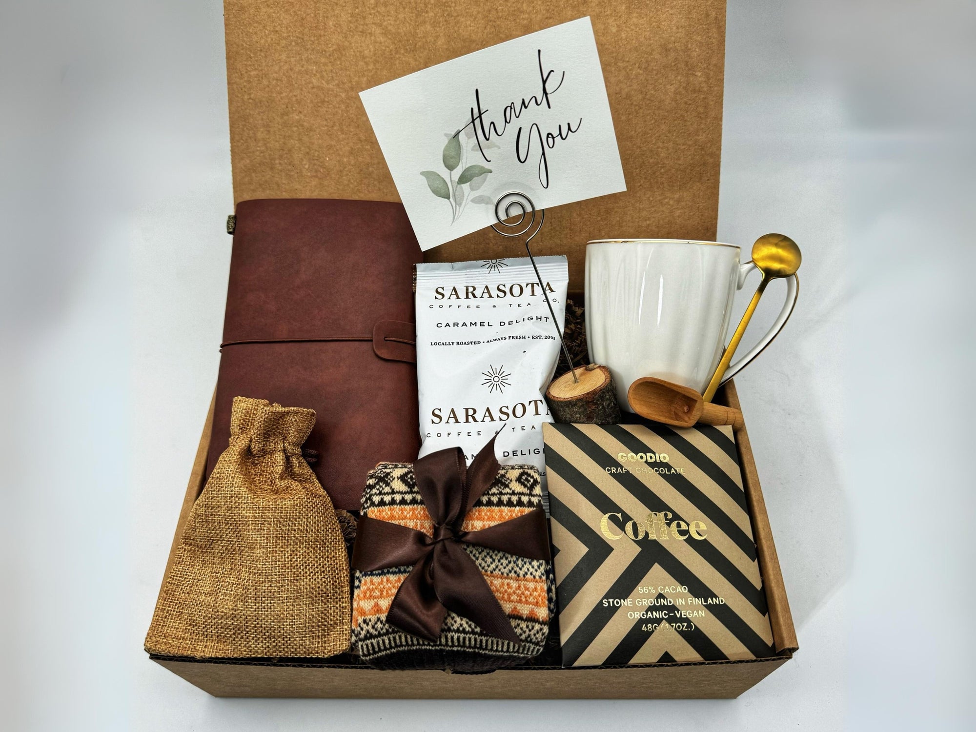 Thank You Gift Box with Sarasota coffee, chocolate, cozy socks, vintage notebook, ceramic mug, burlap bag and golden spoon arranged in a gift box.