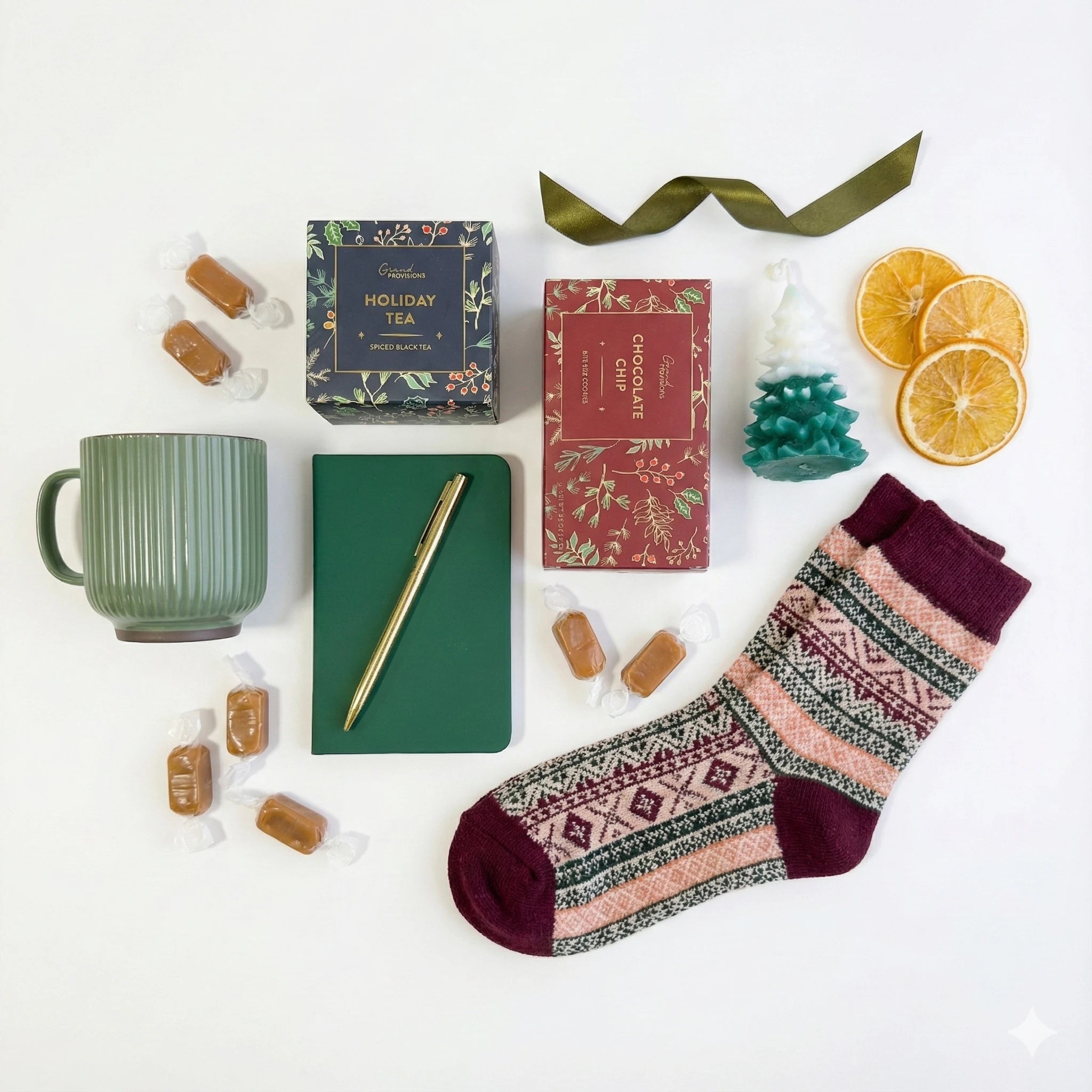 Top down flat lay view of The First Noel box items including chocolate chip cookies and Christmas tree candle