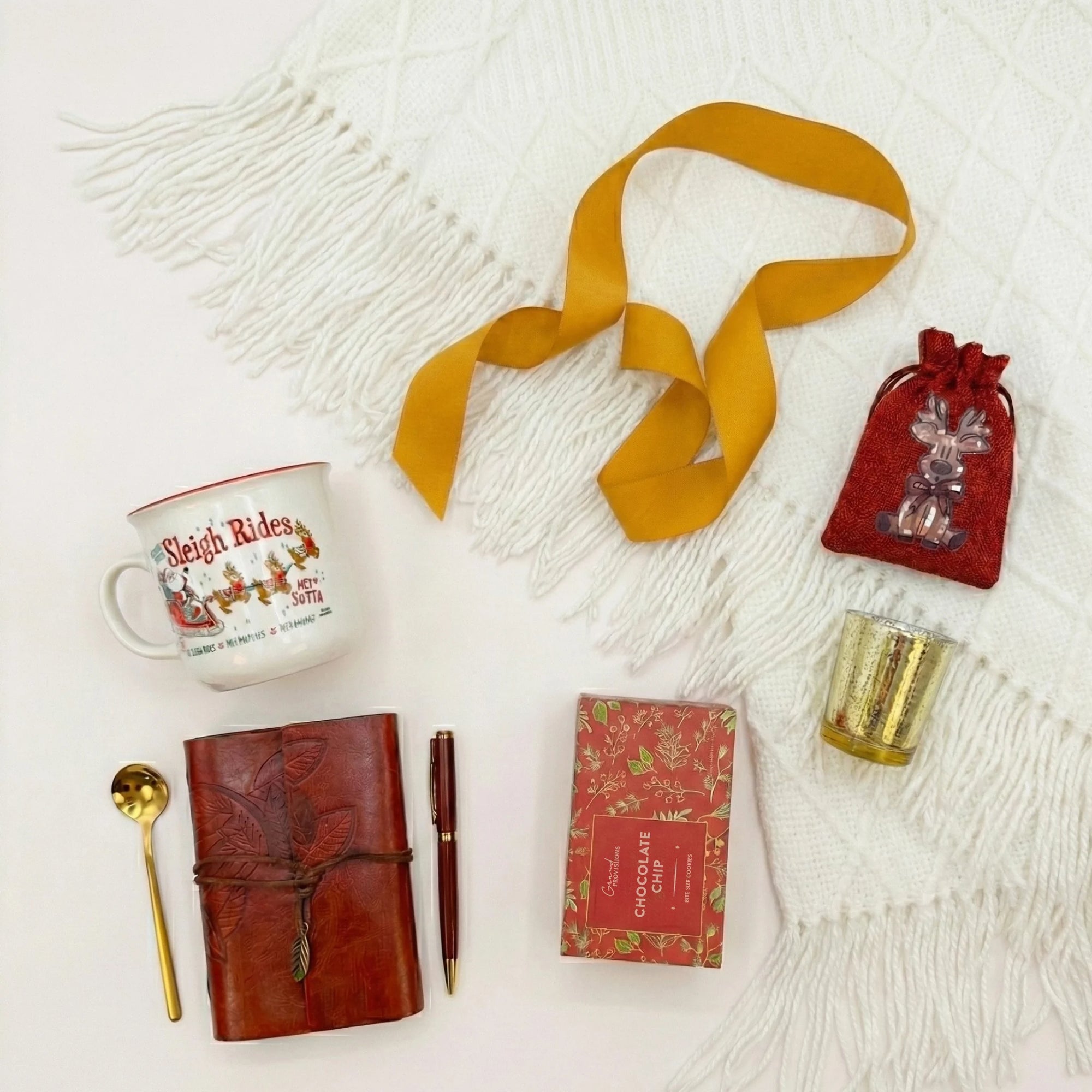 Top down flat lay view of Winter Notes box items including chocolate chip cookies and gold pen