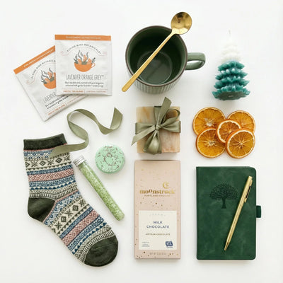 Winter wonderland Christmas gift box with items including socks, a mug, and a notebook on a white background