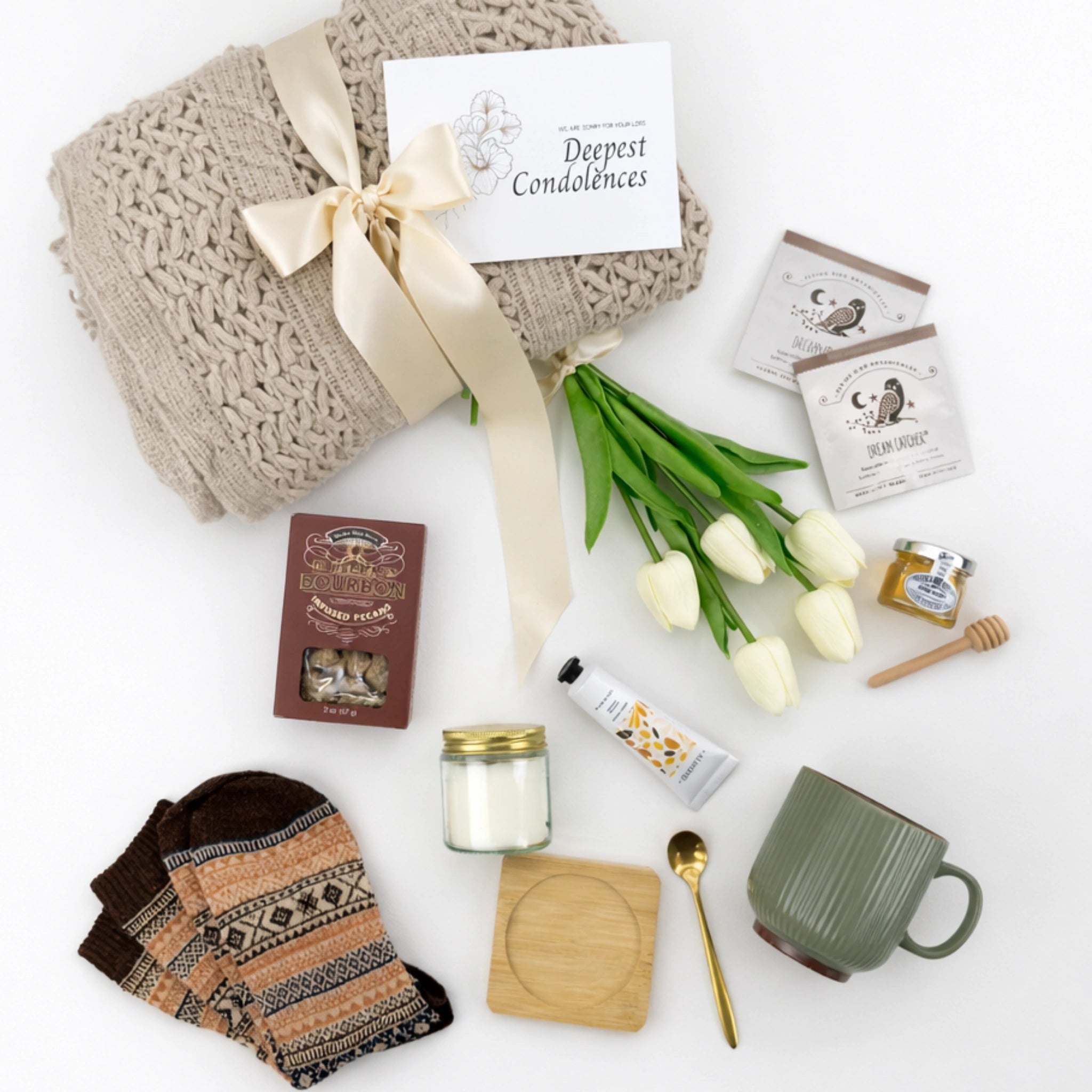 Flat lay sympathy gift box with blanket, tea, honey, candle and cozy socks condolence gift